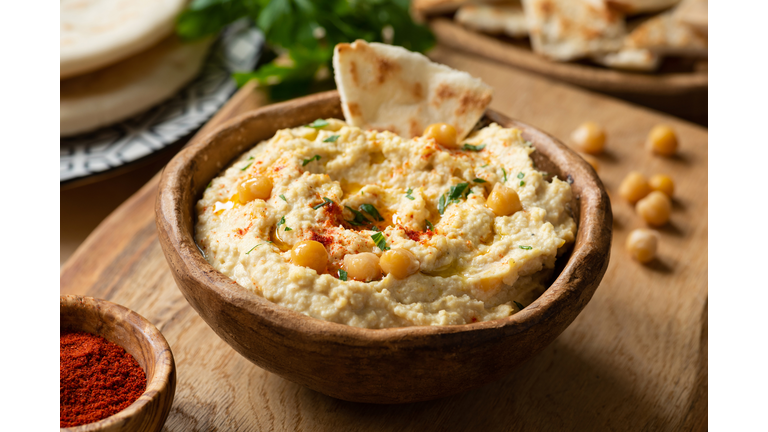 Homemade chickpea hummus bowl with pita chips and paprika