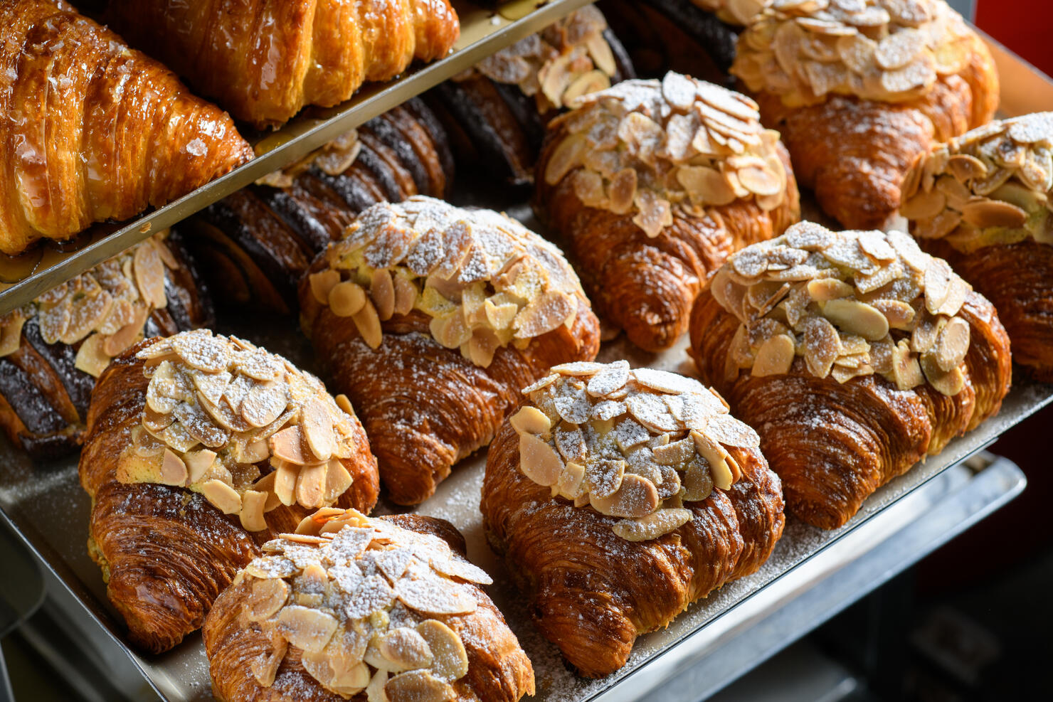 Freshly baked almond croissants display on tray