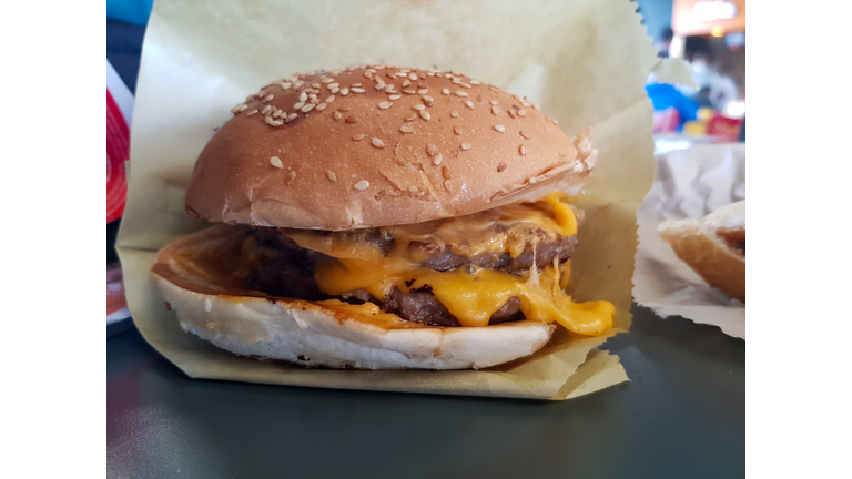 Close up view for meat cheese meat burger in it is paper