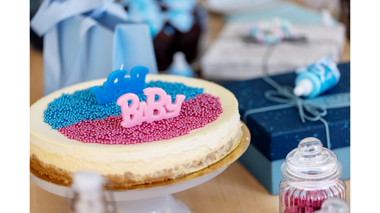 Pink and Blue cake on baby gender reveal party table