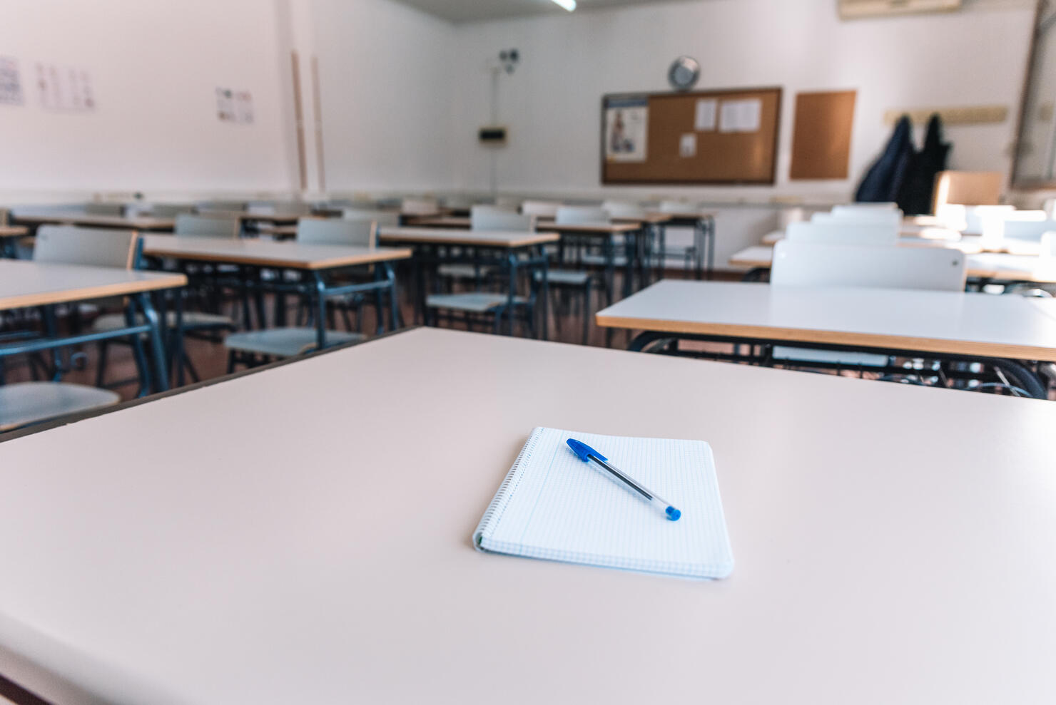Notebook with a pen on a table in a classroom at a school