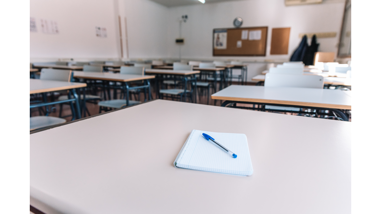 Notebook with a pen on a table in a classroom at a school