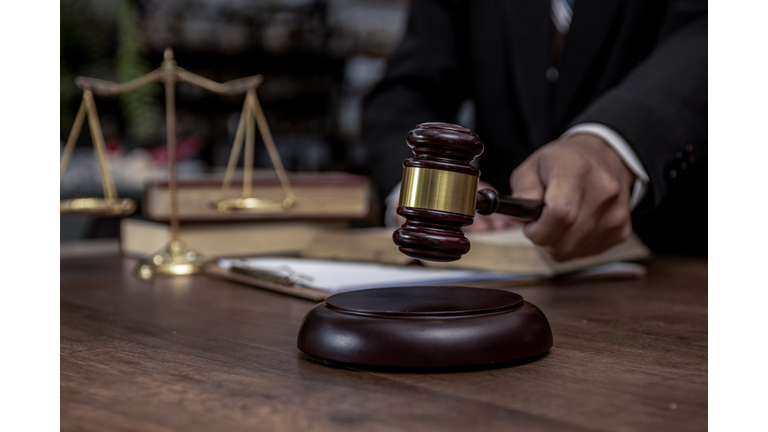 Man hand knocking a wooden judge gavel, law and auction concept.