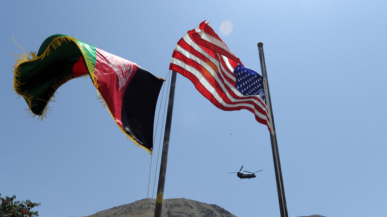 Afghan and US flags are raised as a Chin