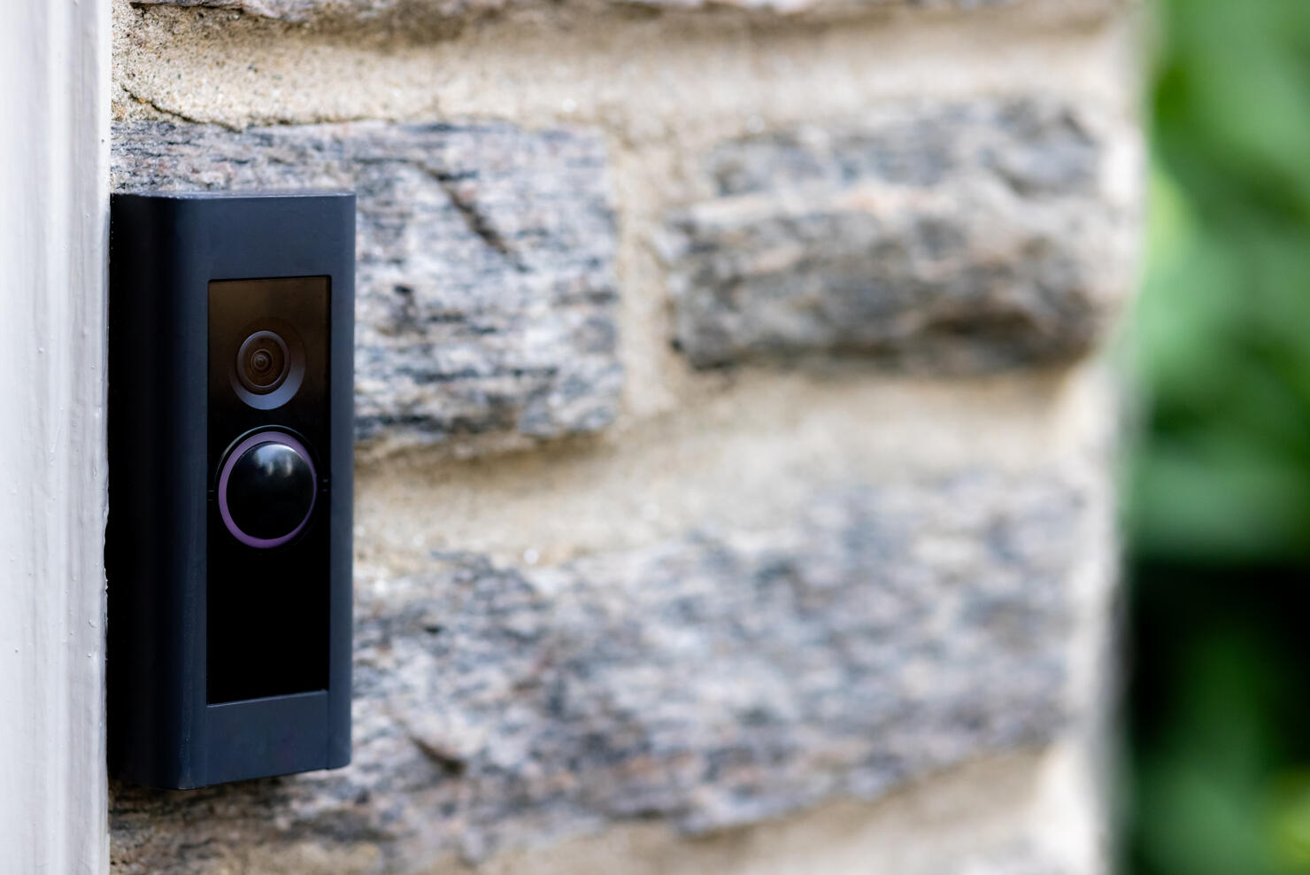 video camera smart doorbell on residential stone wall background