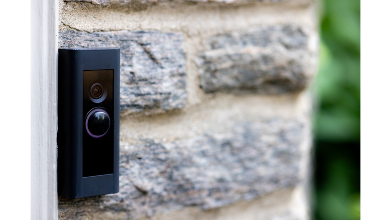 video camera smart doorbell on residential stone wall background