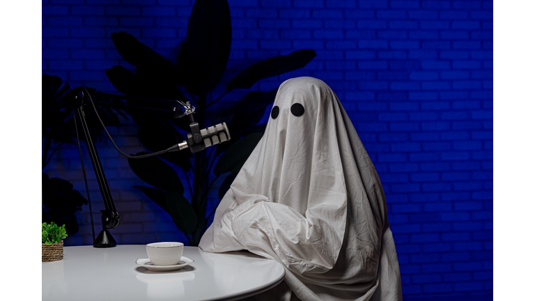 Ghost costume recording podcast in dark studio