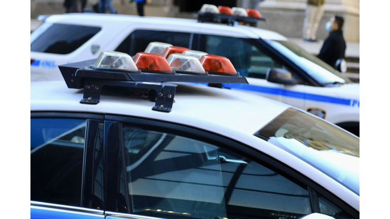 Police vehicles with overhead strobe lights at a crime scene