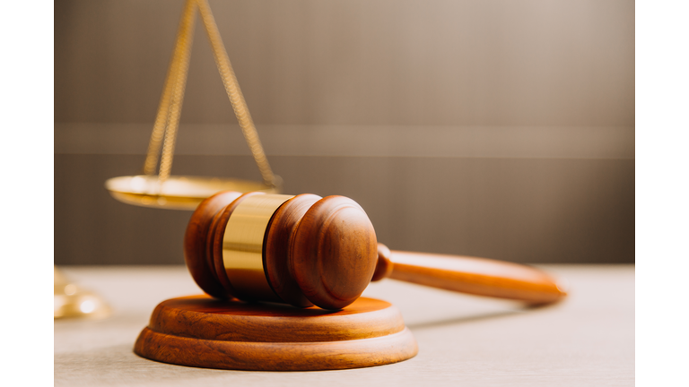 Law books and scales of justice on desk in library of law firm jurisprudence legal education concept,Romania