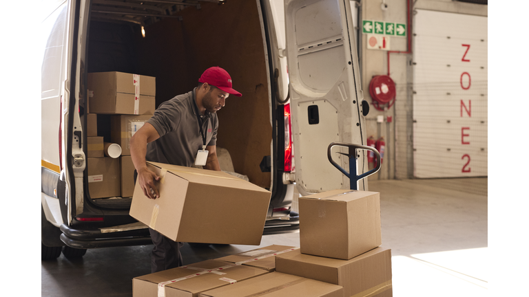 Warehouse worker unloading cardboard boxes