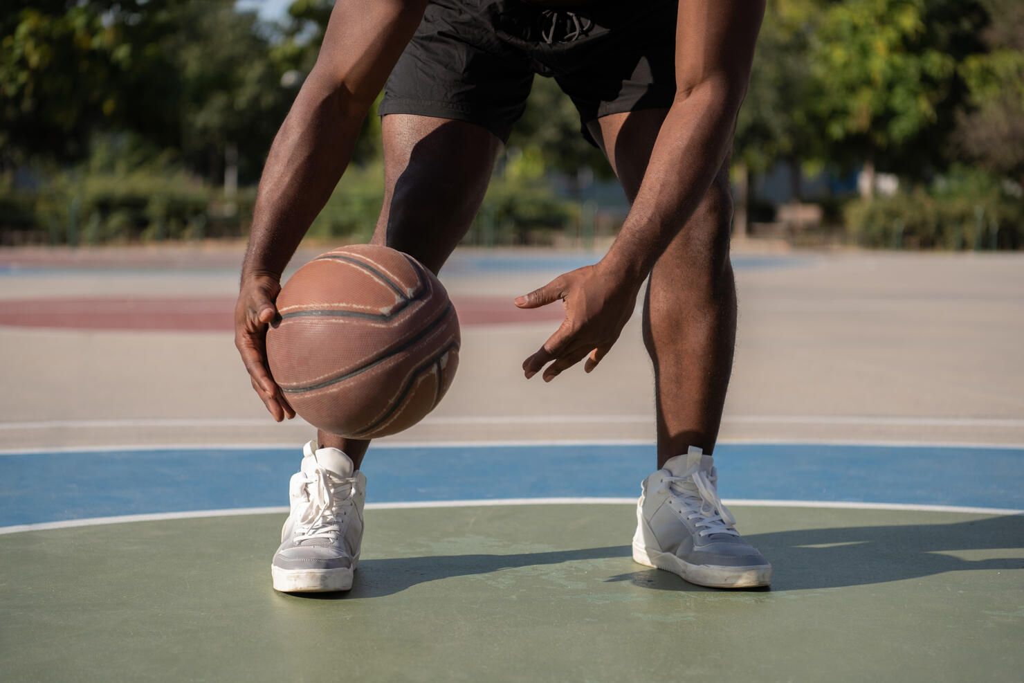 Cropped black athlete dribbling basketball ball