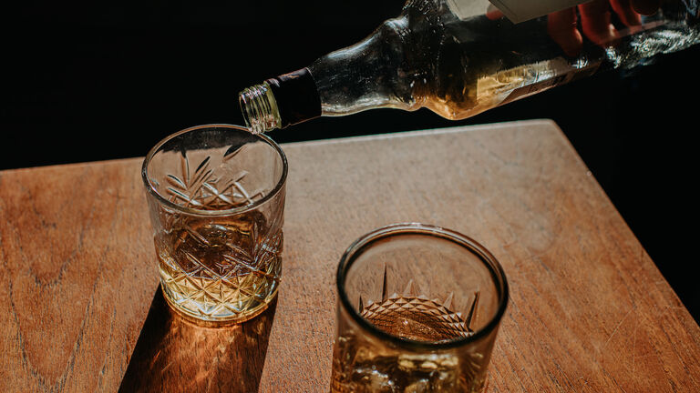 Whisky Pour from a bottle into a cut glass tumbler