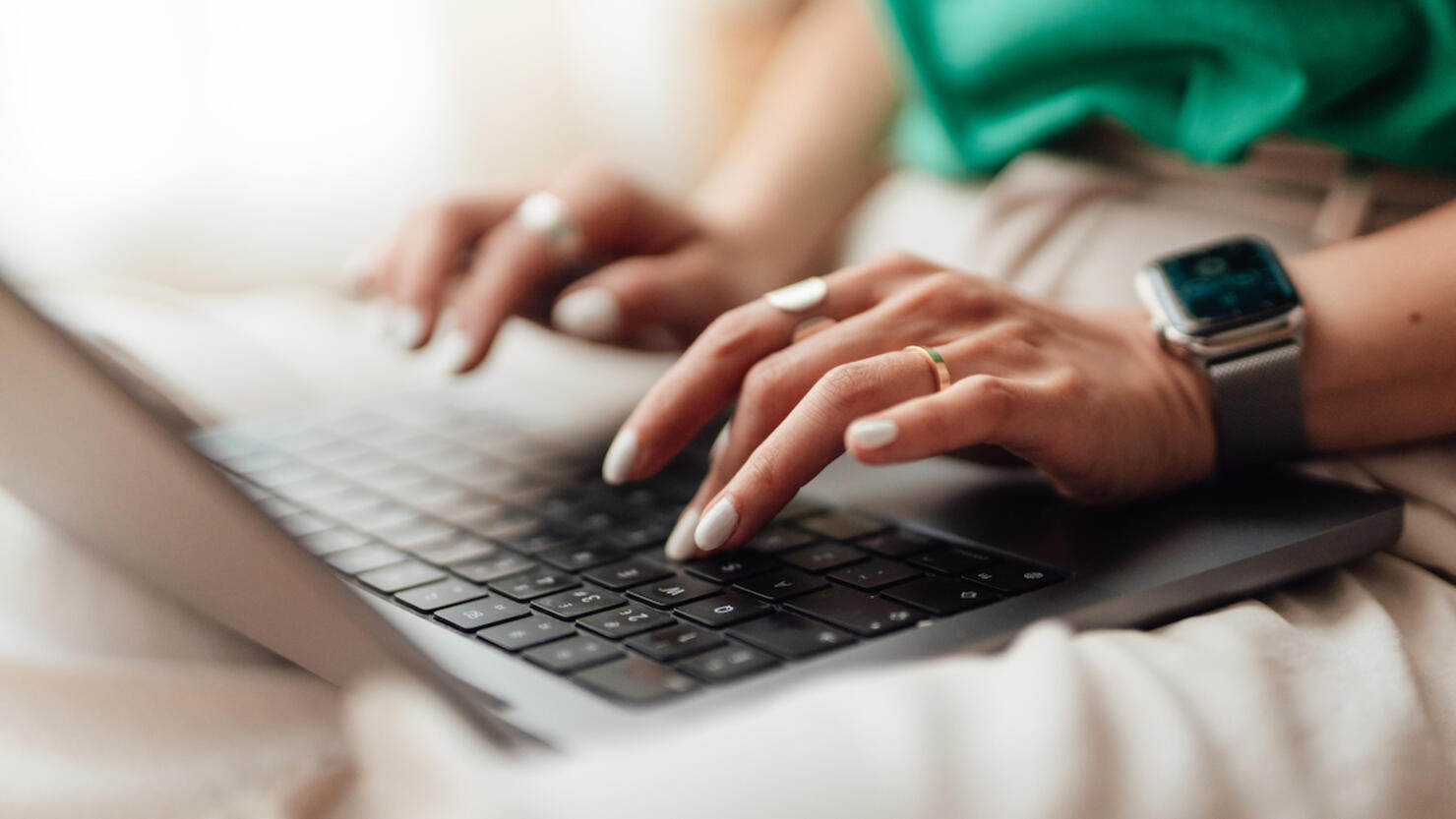 Closeup of female hands typing on laptop keyboard