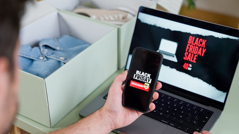 Man shopping online during black friday using laptop and smartphone