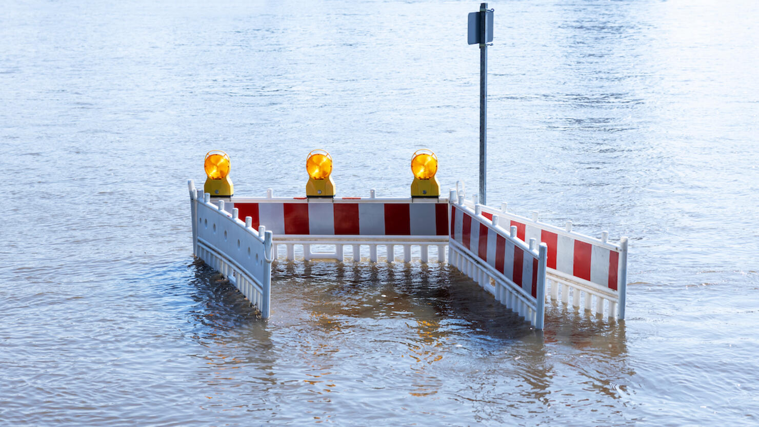 Road barrier one a flooded road in the high tide Elbe river