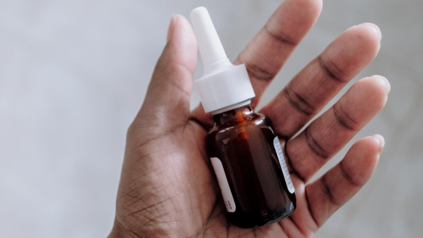 Woman Holds Bottle of Prescription Nasal Spray
